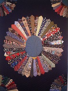 a quilted wall hanging with many different colored ties on it's center circle