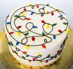 a white cake with multicolored lights on it