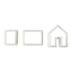 three pieces of white plastic that are shaped like houses and one has a house in the middle