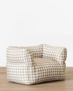 a white and brown checkered chair sitting on top of a wooden floor