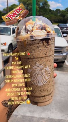 a person holding up a drink with toppings on it