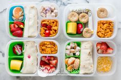 four plastic containers filled with food on top of a marble countertop next to a white table