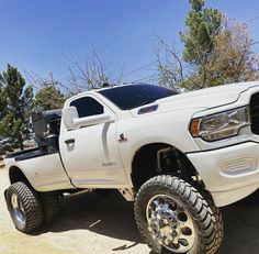 a white truck parked on top of a dirt road