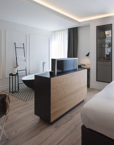 a hotel room with a bed, desk and television on the dresser next to it