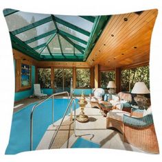 an indoor swimming pool with wicker furniture and large glass roof over the pool area