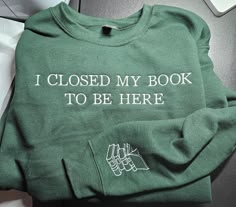 Make a statement with our "I Closed My Book to Be Here" embroidered sweatshirt! Perfect for book lovers who'd rather be reading, this cozy and stylish sweatshirt features a playful design that lets everyone know where your heart truly lies. Whether you're at a social event or just lounging around, this sweatshirt is a fun way to express your love for books. It's the perfect gift for any avid reader who reluctantly puts down their book for the outside world! Crewneck Embroidery Books, Gifts For Book Lovers, Book Embroidered Sweatshirt, Book Lovers Sweatshirt, Cheap Crew Neck Bookish Sweatshirt, Relaxed Fit Crew Neck Bookish Sweatshirt, Sweatshirt Aesthetic, Bracelet Quotes, Hand Embroidery Projects