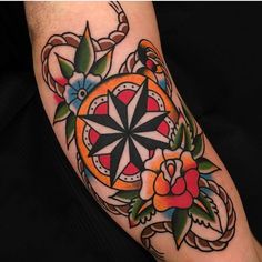 a colorful tattoo on the arm of a person with an orange and black flower design