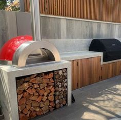 an outdoor bbq grill with firewood stacked in it