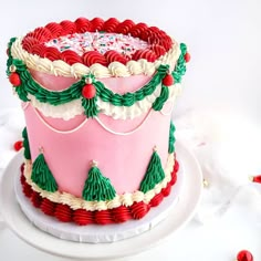 a pink and green christmas cake on a white plate