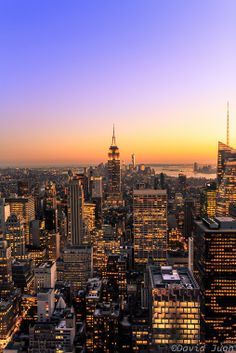 an aerial view of new york city at sunset with the empire building in the foreground