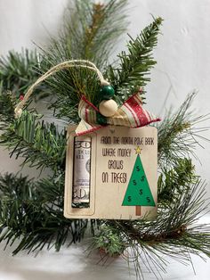 an ornament hanging from a christmas tree with money on it's back