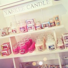 yankee candles are displayed on shelves in a store