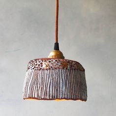 a brown and white lamp hanging from a ceiling