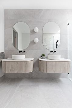 two sinks and mirrors in a bathroom with grey walls, white floors and flooring