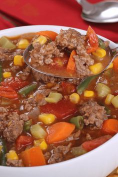 a spoon full of soup with meat and vegetables