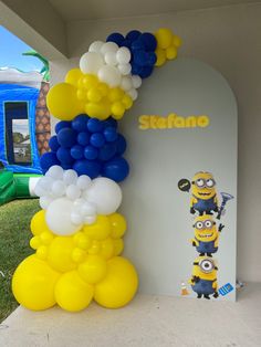 the balloon arch is decorated with minion balloons