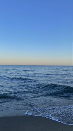 an ocean view with waves coming in to shore