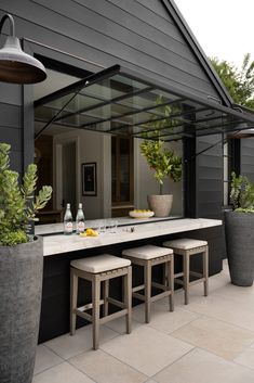 an outdoor kitchen with two stools and a table