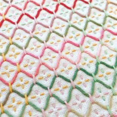 a close up view of a crocheted blanket with different colors and designs on it