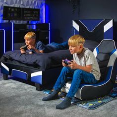 two young boys playing video games on their phones in a room with blue walls and carpet