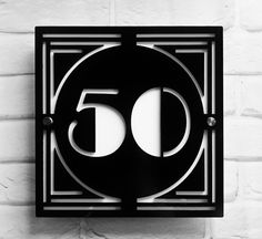 a black and white photo of the number 50 on a brick wall with an iron frame