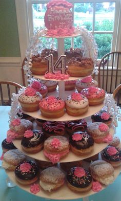 a three tiered tray filled with donuts and cupcakes on top of each other