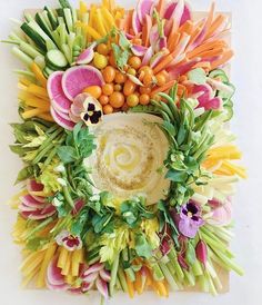 an arrangement of flowers and vegetables arranged in the shape of a circle