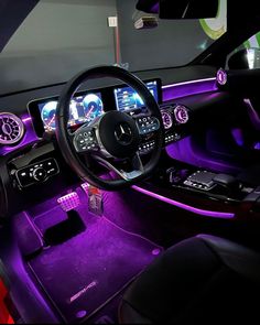 the interior of a car with purple lighting