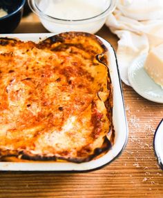 a casserole dish with cheese and sauce on the side