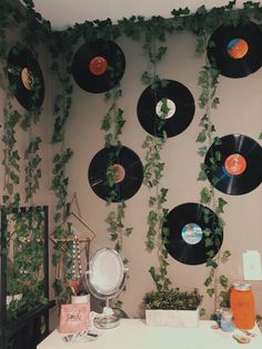 there are many records on the wall with plants growing out of them and hanging from it's sides