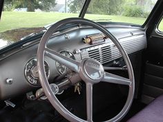 the interior of an old car with steering wheel and dashboard