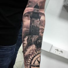 a man with a clock and lighthouse tattoo on his arm