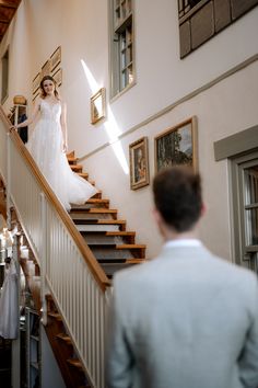 the bride is walking down the stairs in her wedding dress