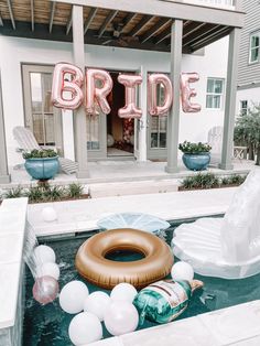 an inflatable bride balloon sitting on top of a pool next to some balloons