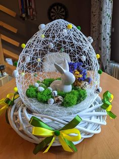 an easter egg with moss and eggs in the shape of a bunny sitting inside it