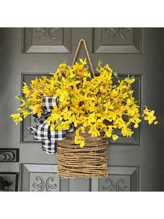 a basket filled with yellow flowers hanging from a door