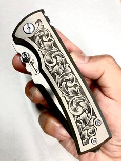 a hand holding a lighter in it's right hand and an ornate design on the outside