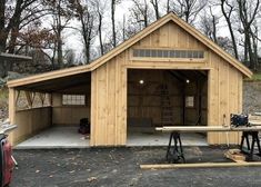 a large wooden garage sitting in the middle of a forest