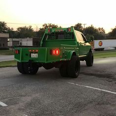 a green pick up truck parked in a parking lot