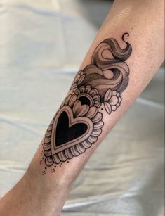 a woman's leg with a tattoo on it and a heart in the middle