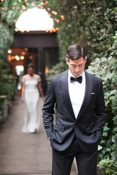 a man in a tuxedo standing next to a woman