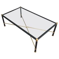 a glass and brass coffee table with two legs on each side, the top is turned upside down