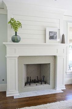 a white fireplace in a living room with wood floors