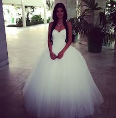 a woman in a white wedding dress posing for the camera