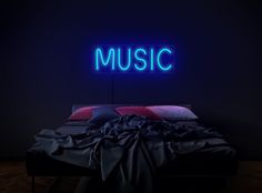 a bed in a dark room with a neon sign above it that says music on the wall