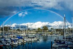 a rainbow is in the sky over a marina