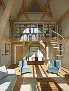 a living room with two blue chairs and a spiral stair case in the middle of it