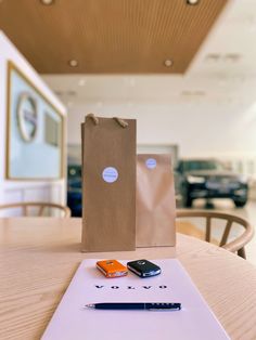 a brown paper bag sitting on top of a table next to a cell phone