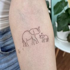 an elephant and her baby are depicted on the arm, while it's mother is standing behind them