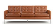 a brown leather couch sitting on top of a metal frame